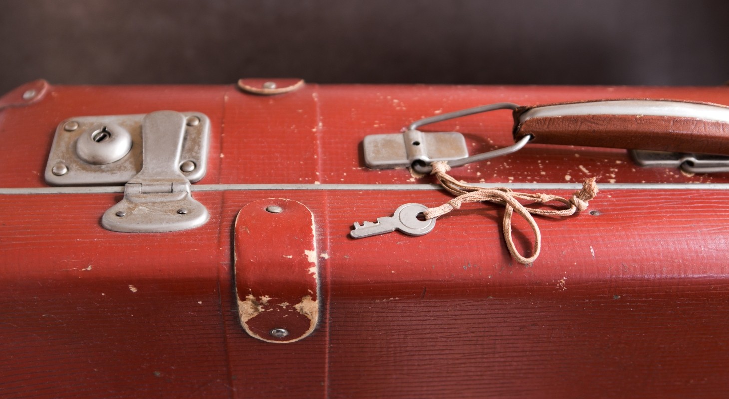 closeup of vintage red suitcase lock and key