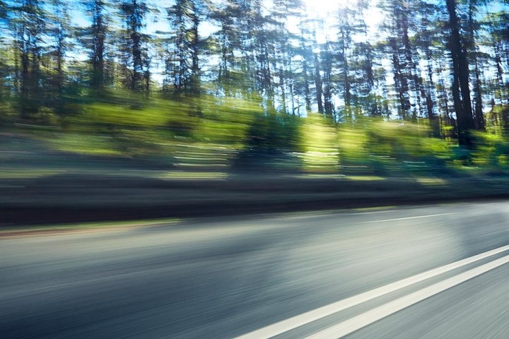 blurred view of trees along highway