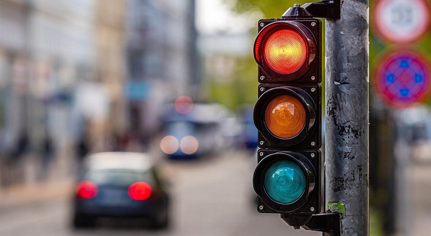 red traffic light with blurred car in background