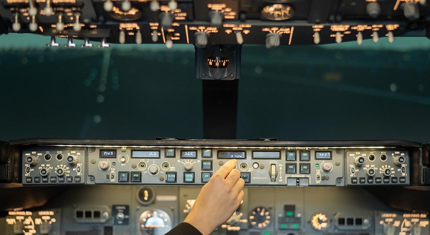 female airline pilots hand on control panel