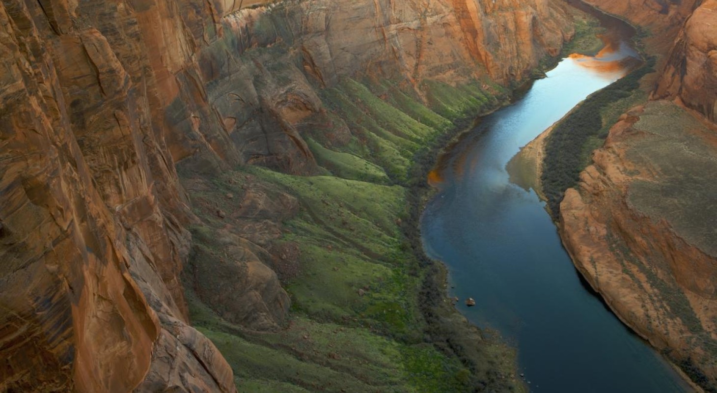 bend in the colorado river with orange canyon rising above