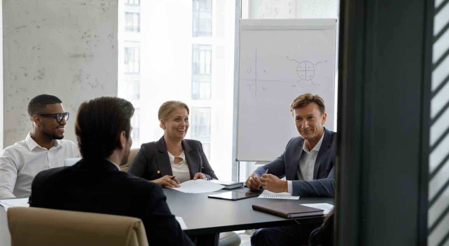 small conference room with four person board meeting