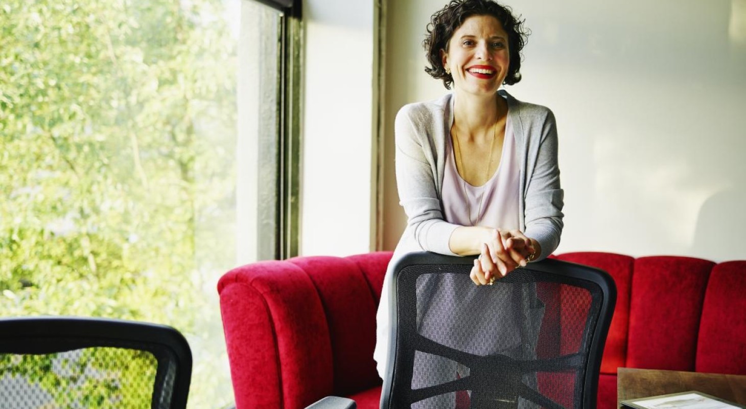 female executive standing behind office chair