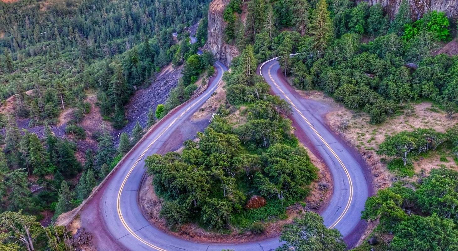 aerial view of hairpin turn in the road in a forested area