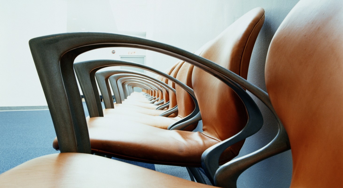 row of empty brown leather chairs with black arms