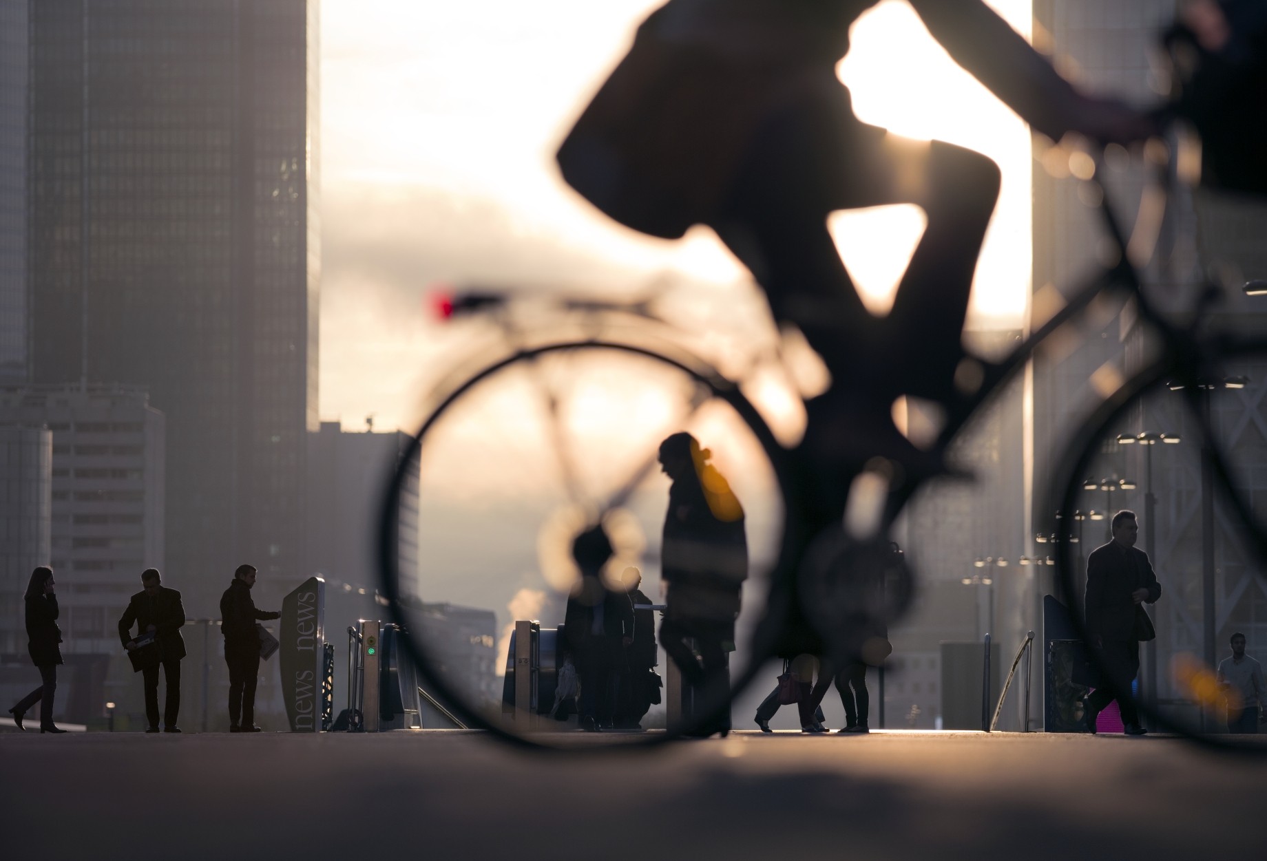 Silhouette of business person on bicycle on busy street