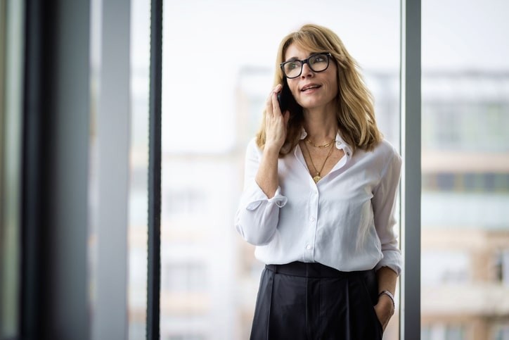woman with her smartphone standing at the office
