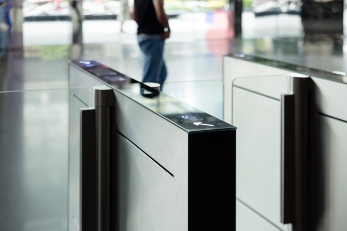 A man walks past a pair of electronic turnstiles