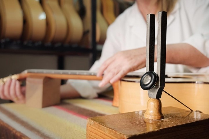 close up of woman tuning guitar