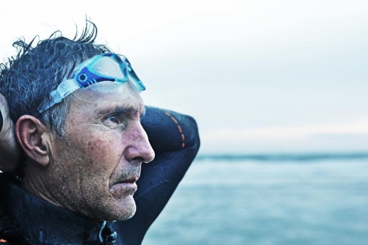 retired man gazing at ocean after a swim