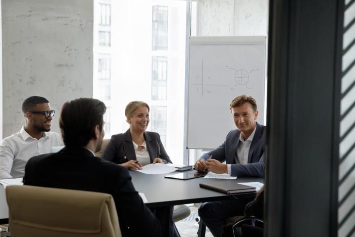 small conference room with four person board meeting