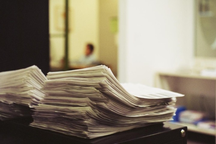 stack of paperwork on top of black cabinet