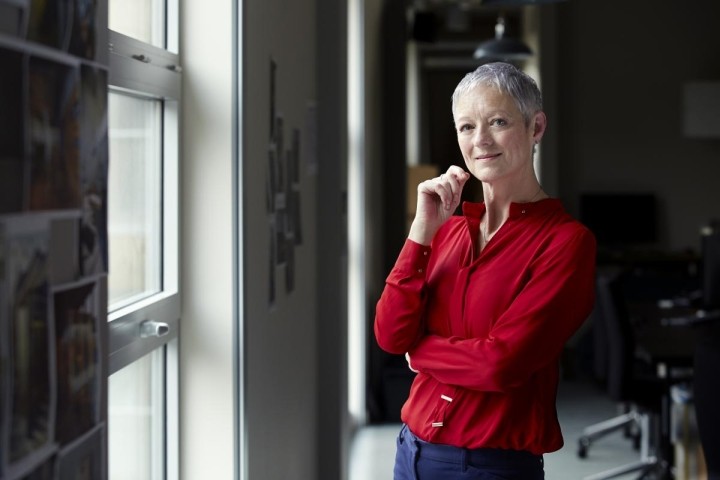 female executive with cropped gray hair in bright red blouse