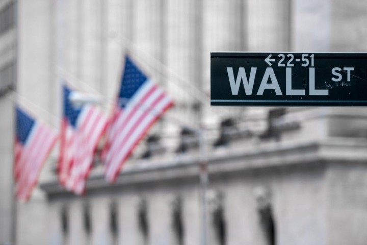wall street sign with flags blurred in background
