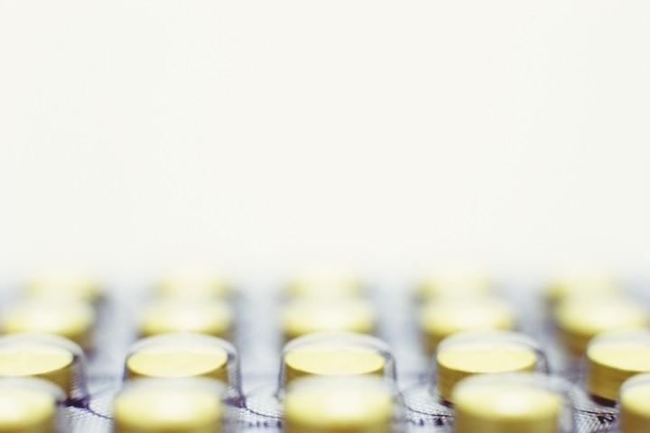 close up of round yellow pills in blister pack