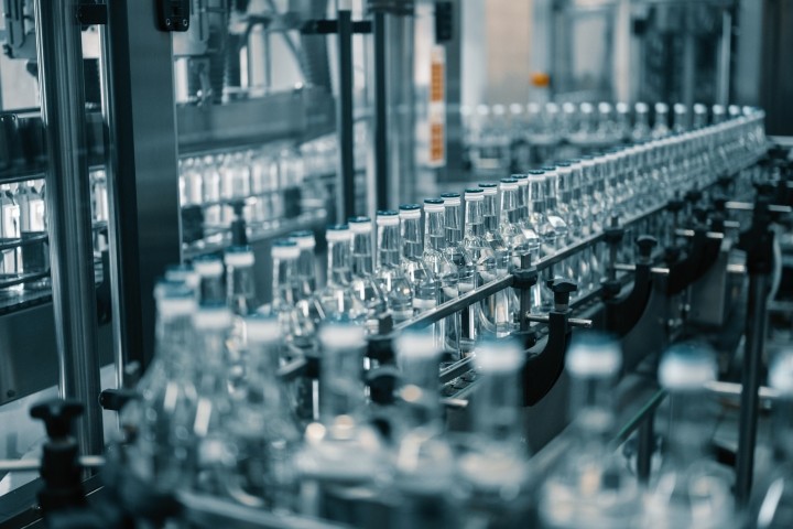 closed glass bottles of upscale vodka transported by line