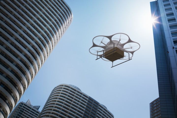 Delivery drone flying above high rise apartments