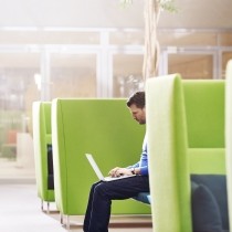 man working on laptop in lime green booth