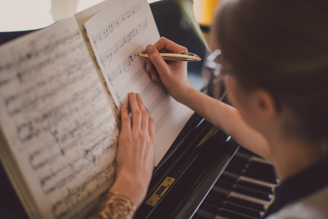 woman-writing-down-music-notes